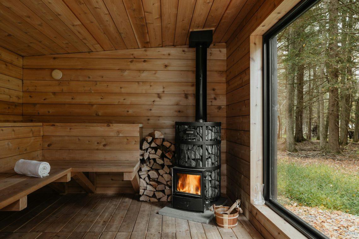 A wood burning stove inside of a wooden cabin