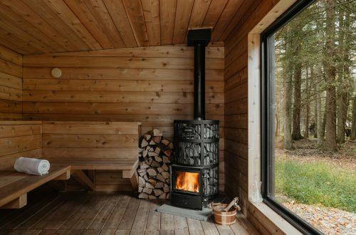 A wood burning stove inside of a wooden cabin